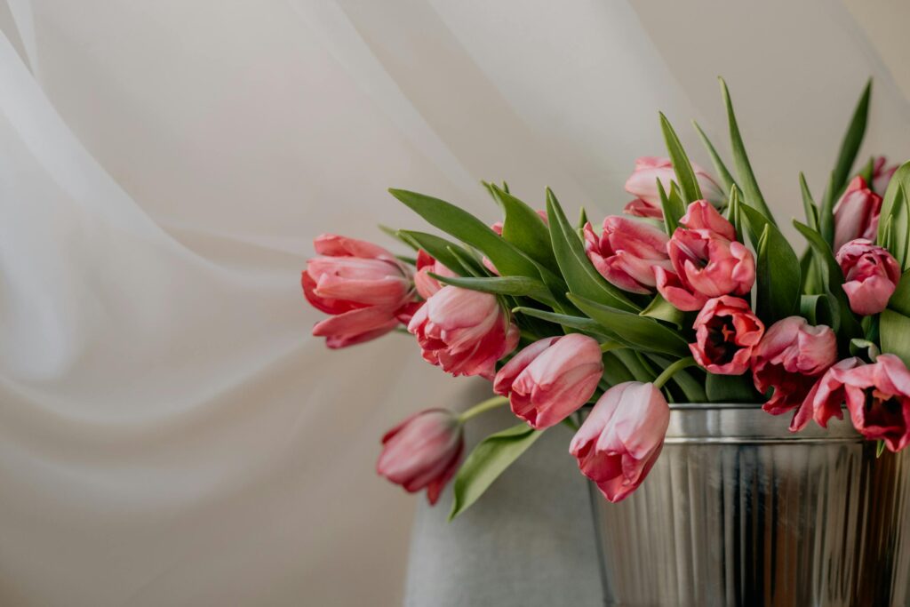 Charming arrangement of pink tulips in a metal vase on a white background.
